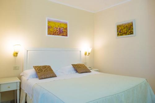 维耶斯泰Hotel Seggio的卧室配有一张床,墙上挂有两张照片