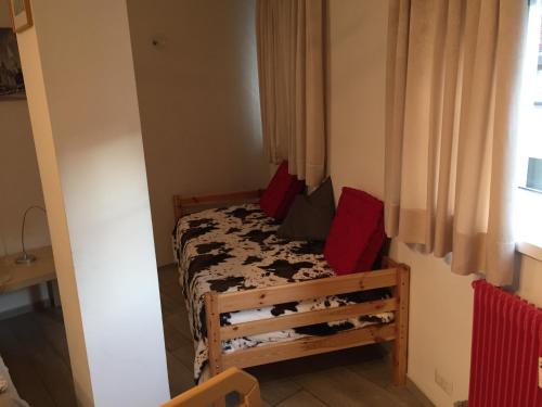 博尔扎诺博尔扎诺中心劳林公寓的小卧室配有红色枕头的床