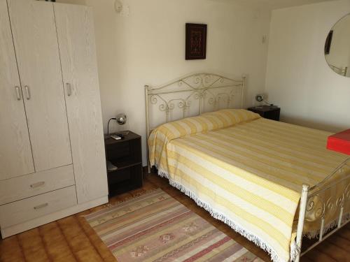 加利亚诺德尔卡波Santa Maria Di Leuca Villa Etta的一间卧室配有一张床和一个梳妆台
