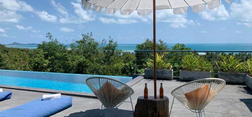 蓝赛特海滩Sky Villa Seren with free car的一个带椅子和遮阳伞的庭院和一个游泳池