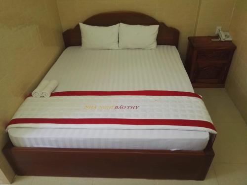 朱笃宝祢酒店的一张带木制床头板和白色床单的床