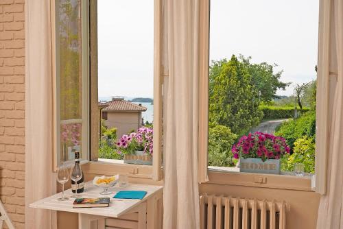 加尔多内-里维耶拉VALLE FIORITA 42 - Lake view Studio的一间设有桌子和鲜花窗户的客房