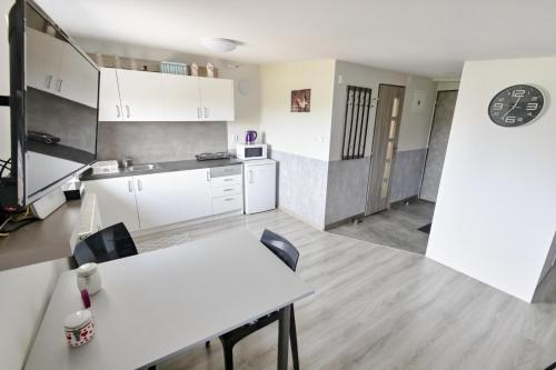 维尔奇斯拉夫科夫Apartmán Theo的厨房配有白色橱柜和桌椅