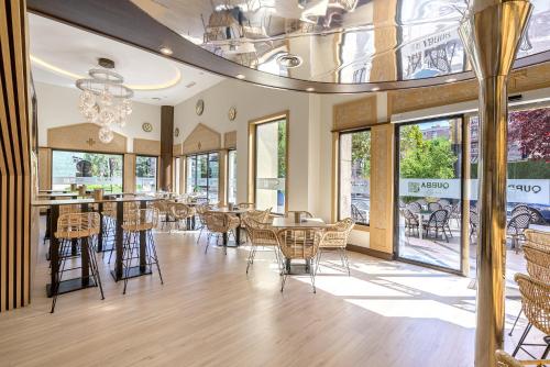 格拉纳达萨雷酒店的用餐室设有桌椅和窗户。