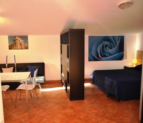 Infernetto斯美拉尔多罗马别墅酒店的一间卧室配有一张床和一张桌子及椅子