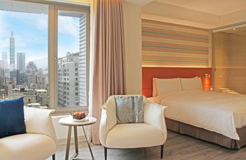 台北台北美仑大饭店的一间卧室配有一张床、两把椅子和一个窗户