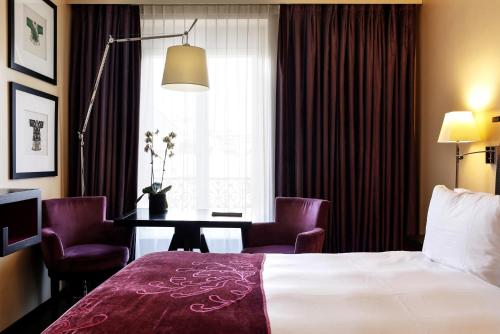 日内瓦东西方酒店的酒店客房,配有一张床和一张桌子及椅子