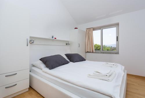 布尔扎克Molnar Resort Apartment Ljiljana的白色的卧室设有白色的床和窗户。