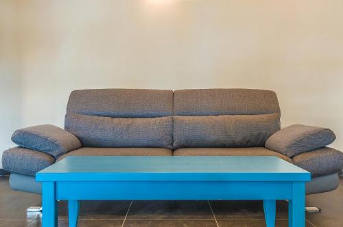 韦内雷港VILLA CASTELLo PORTOVENERE的一张沙发,一张蓝色桌子