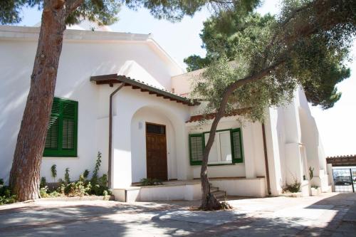 蒙德罗Villa Mallandrino的白色的房子,有绿色百叶窗和一棵树