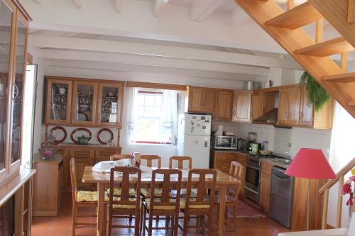 拉日什杜皮库阿瓜达别墅的厨房配有木制橱柜和桌椅