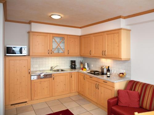 多弗加斯坦加施泰因旅馆的厨房配有木制橱柜和红色椅子
