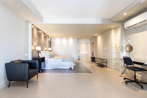 阿雷西费Rooms & Suites Loft 2E Deluxe Edition Arrecife的酒店客房,配有一张床、一张桌子和椅子