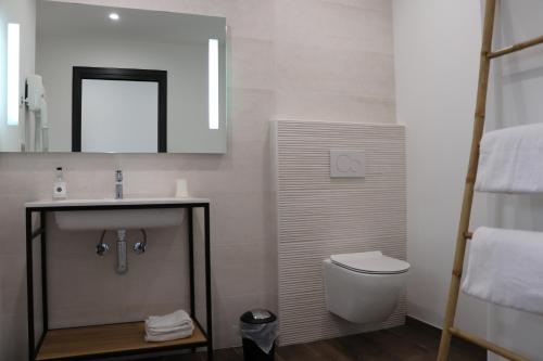 博尼法乔Hotel Fazio的一间带水槽、卫生间和镜子的浴室