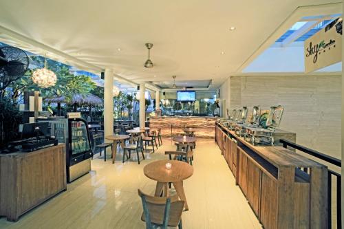 雅加达拉松纳标志酒店的一间带桌椅的餐厅和一间酒吧