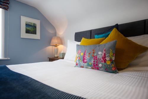 灵伍德Moortown Lodge B&B的卧室配有白色的床和色彩缤纷的枕头