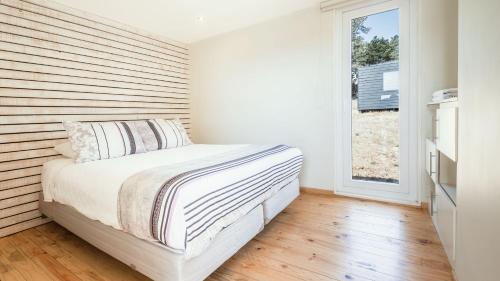 皮奇勒姆Curi Lodge Pichilemu的一间卧室配有一张木墙床