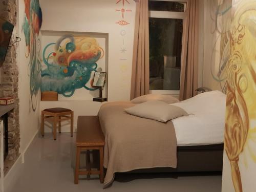 海尔伦B&B The Project的卧室配有一张床,墙上挂有绘画作品