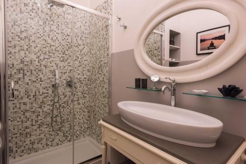 锡罗洛Tra gli Alberi e il Mare的浴室配有盥洗盆和带镜子的淋浴