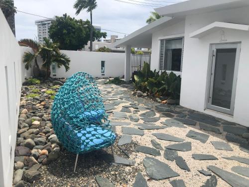 圣胡安MAR DEL NORTE的坐在房子旁边的院子里的蓝色椅子