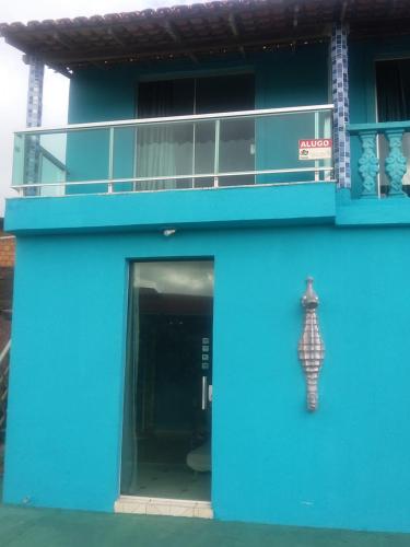萨利诺波利斯Apartamentos no Farol Velho的蓝色的建筑,旁边是雕像