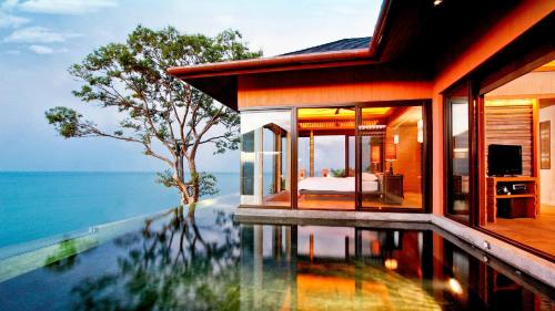 攀瓦海滩Sri Panwa Phuket Luxury Pool Villa Hotel - SHA Plus的海边带游泳池的房子