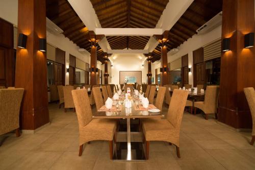 贾夫纳The Thinnai - All-Suites Boutique Hotel的一间带长桌和椅子的用餐室