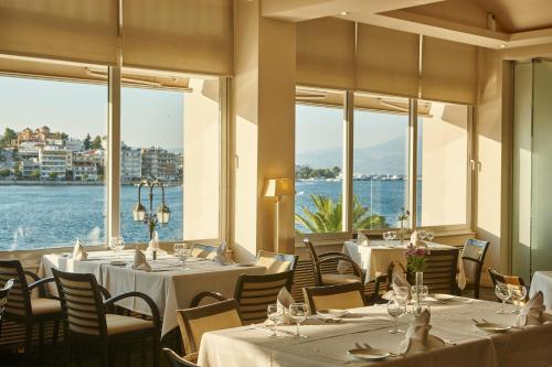哈尔基斯露西酒店的一间设有桌椅并享有水景的餐厅