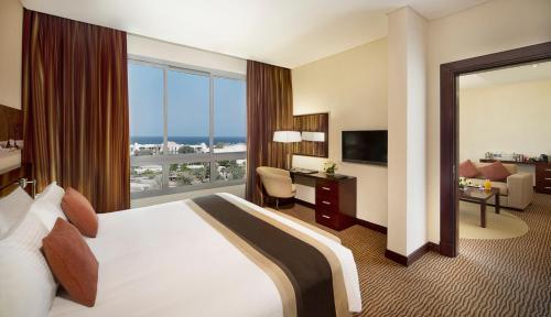 马斯喀特City Seasons Hotel & Suites Muscat的酒店客房设有一张床和一个大窗户