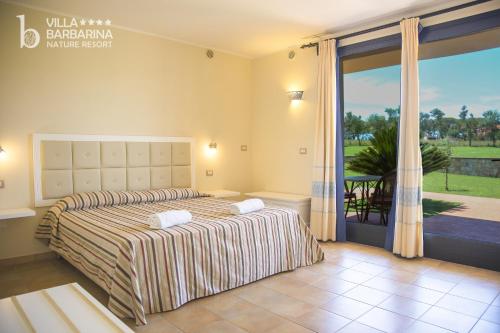 圣塔·马里亚·迪·帕尔玛Villa Barbarina Nature Resort的一间卧室设有一张床和一个大窗户