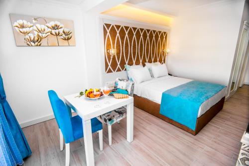 厄吕代尼兹海之蓝高级Spa酒店的酒店客房带一张床、一张桌子和椅子