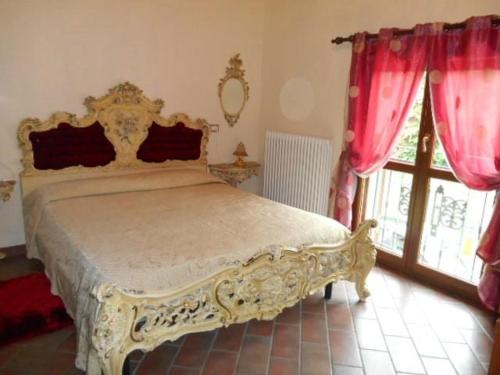 卢戈Ca' Bianca的一间卧室配有一张带红色窗帘的大床