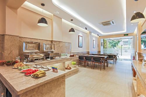 胡志明市黄兰酒店的大型厨房设有大柜台,配有桌椅