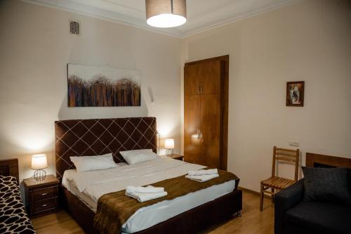 第比利斯Tbilisi Apartment 2的一间卧室配有一张大床和一把椅子