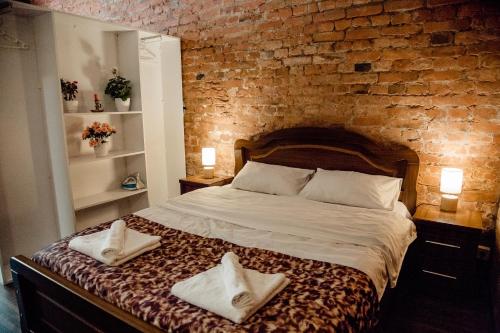 第比利斯Tbilisi Apartment的一间卧室设有砖墙和一张带两条毛巾的床