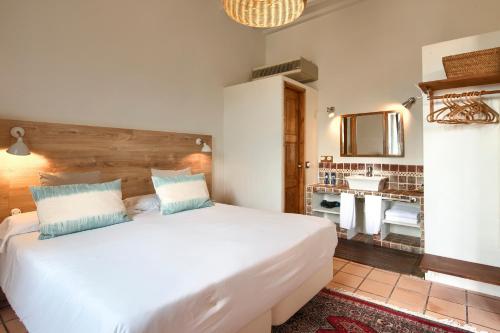 巴古尔河内酒店的卧室配有白色大床和水槽