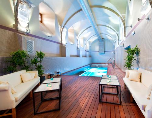 坎加斯德尔纳尔塞亚科瑞阿斯酒店的客厅设有游泳池、沙发和桌子