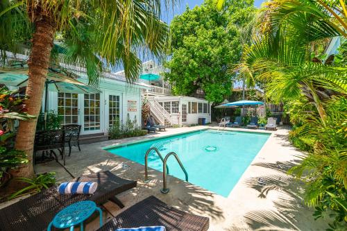 基韦斯特玫瑰巷别墅的一座棕榈树游泳池和一座房子
