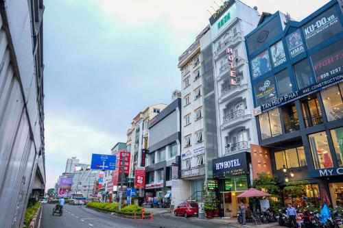 胡志明市H79 HOTEL的一条繁忙的城市街道,有许多建筑和汽车