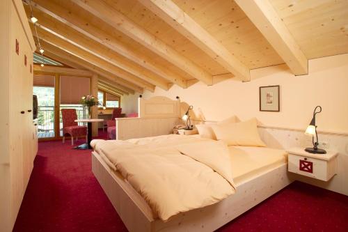 基茨比厄尔Aktiv Hotel Schweizerhof Kitzbühel的一间卧室配有一张大床,铺有红地毯