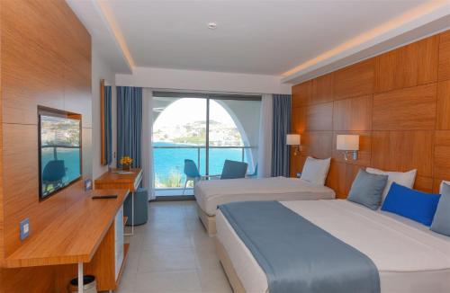 库萨达斯INFINITY BY YELKEN AQUAPARK&RESORTS KUŞADASI的酒店客房设有两张床和窗户。