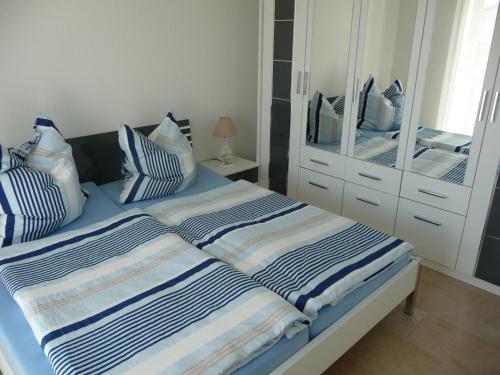 格拉尔-米里茨Ferienwohnung am Rhododendronpark, 300 m zum Strand的一间卧室配有一张带蓝色和白色枕头的床