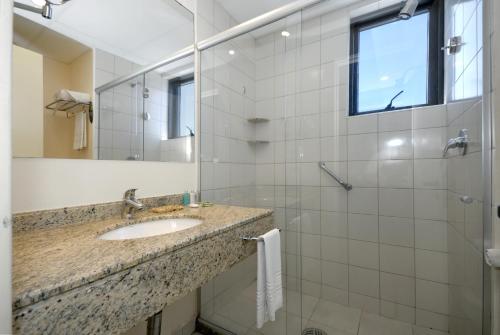 萨尔瓦多Rede Concept - Hotel Salvador的浴室配有盥洗盆和带镜子的淋浴