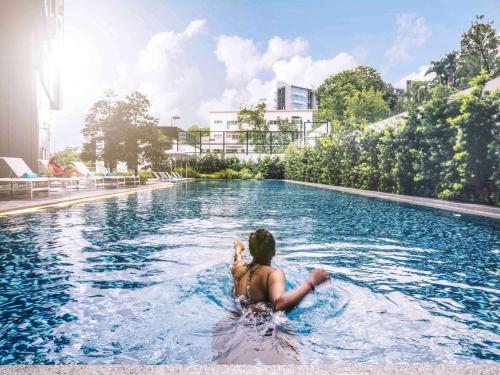 新加坡史蒂文生美爵新加坡酒店的躺在游泳池里的女人