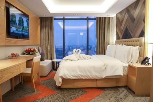 达卡汉萨高级住宅公寓的配有一张床、一张书桌和一扇窗户的酒店客房