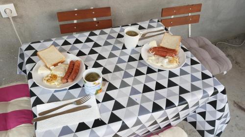蒂瓦特Sobe Tivat的一张桌子,上面有两盘食物和两只热狗