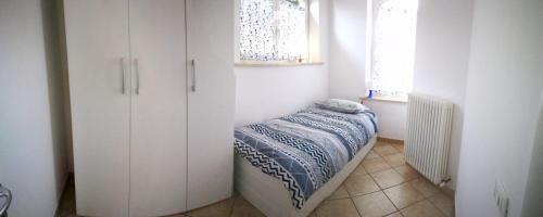 奥西莫La casa di Lalla的一间设有白色橱柜和一张床的房间