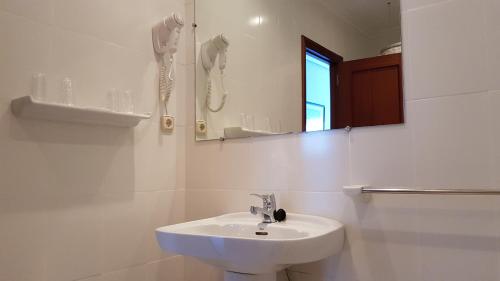 诺哈蒙特马尔酒店的白色的浴室设有水槽和镜子
