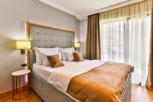 布德瓦Hotel Lusso Mare by Aycon的一间卧室设有一张大床和一个大窗户