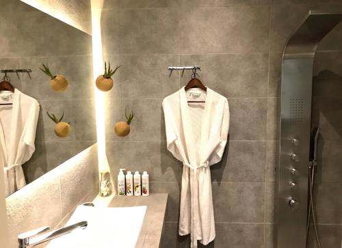 梅松吉Palms and Spas Villas Retreat的浴室设有悬挂在淋浴间的白色长袍